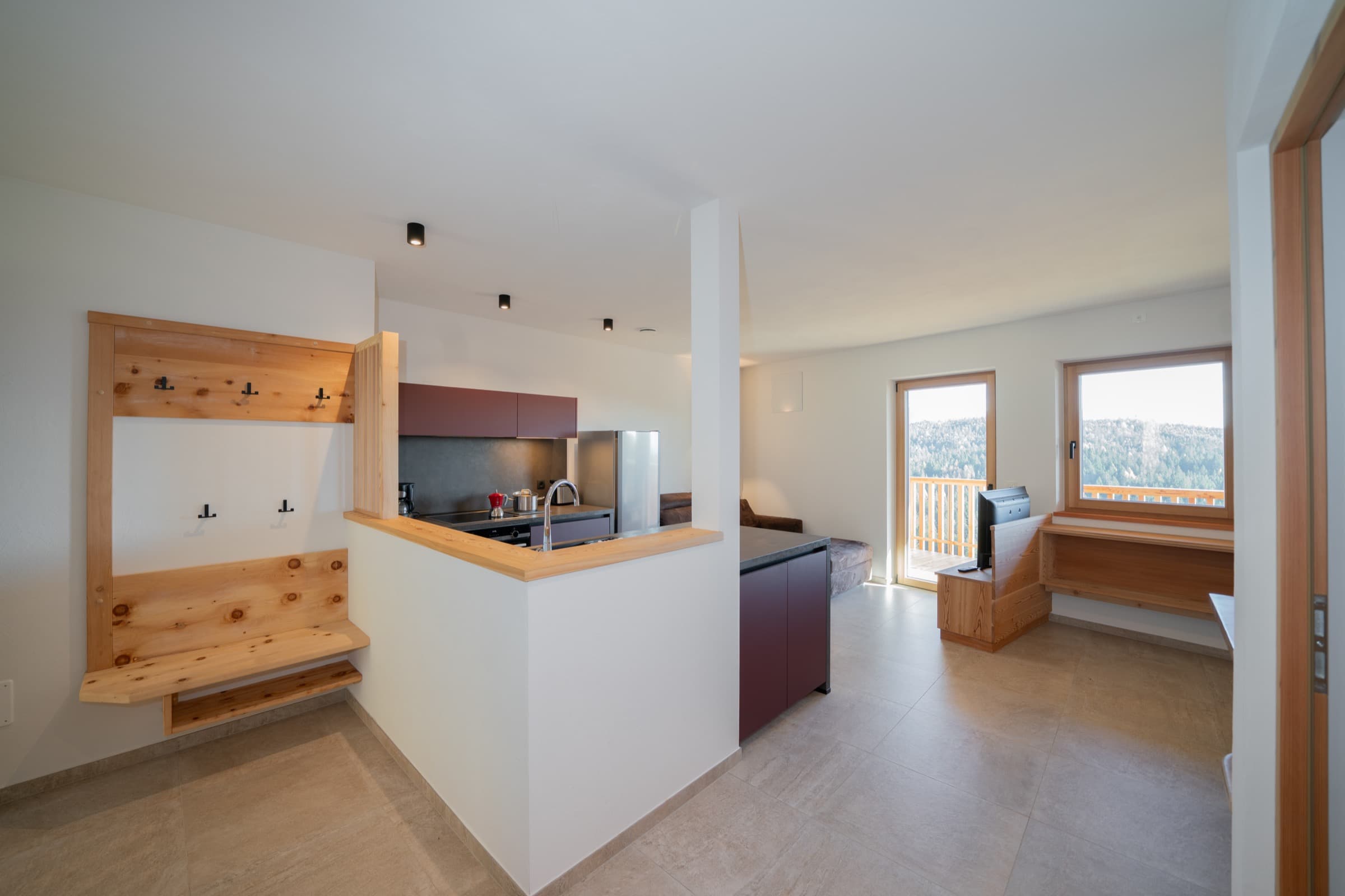 Wohnraum mit offener Balkontür und Blick auf den Wald
